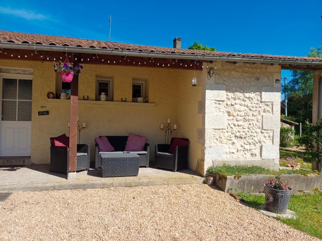 eine Terrasse eines Hauses mit Stühlen und einem Tisch in der Unterkunft Large 4 bed house available for short stays in Petit-Bersac