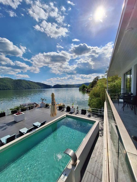 a swimming pool on a house with a view of the water at Pensiunea Sunshine in Eşelniţa