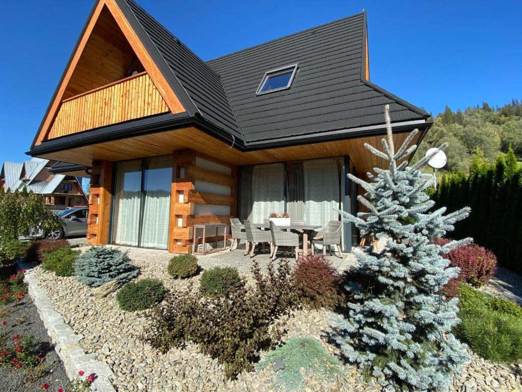 波罗宁Luxury Chalet Wioska Jagny的院子里的小木屋,有圣诞树