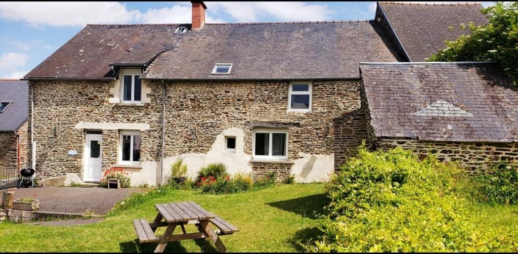 une maison en briques avec une table de pique-nique devant elle dans l'établissement Les Frangins du Mont Saint Michel, à Pontorson