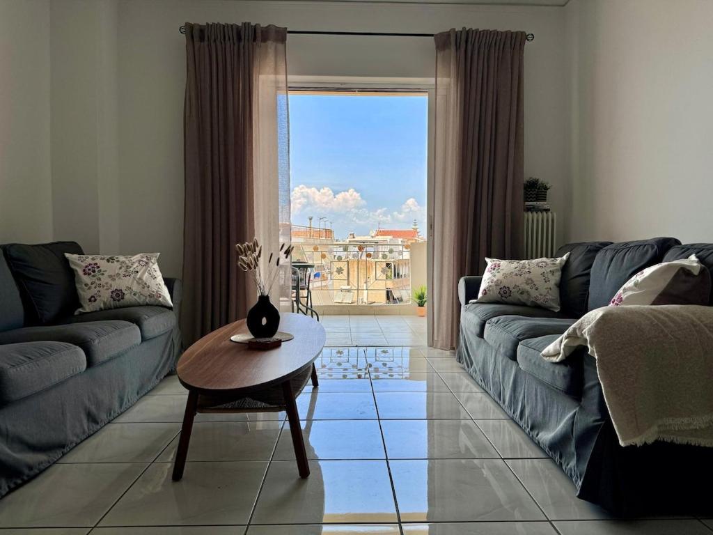 a living room with a couch and a table at J&J spacious balcony apartment in Preveza