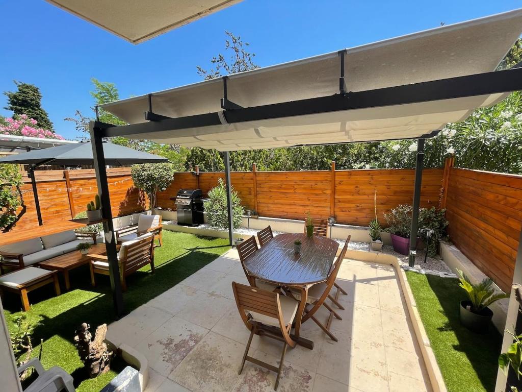 un patio avec une table et un parasol dans l'établissement Le Cosy, à Hyères