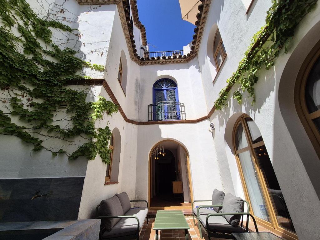a courtyard in a building with chairs and a table at BHost - Palace in Córdoba