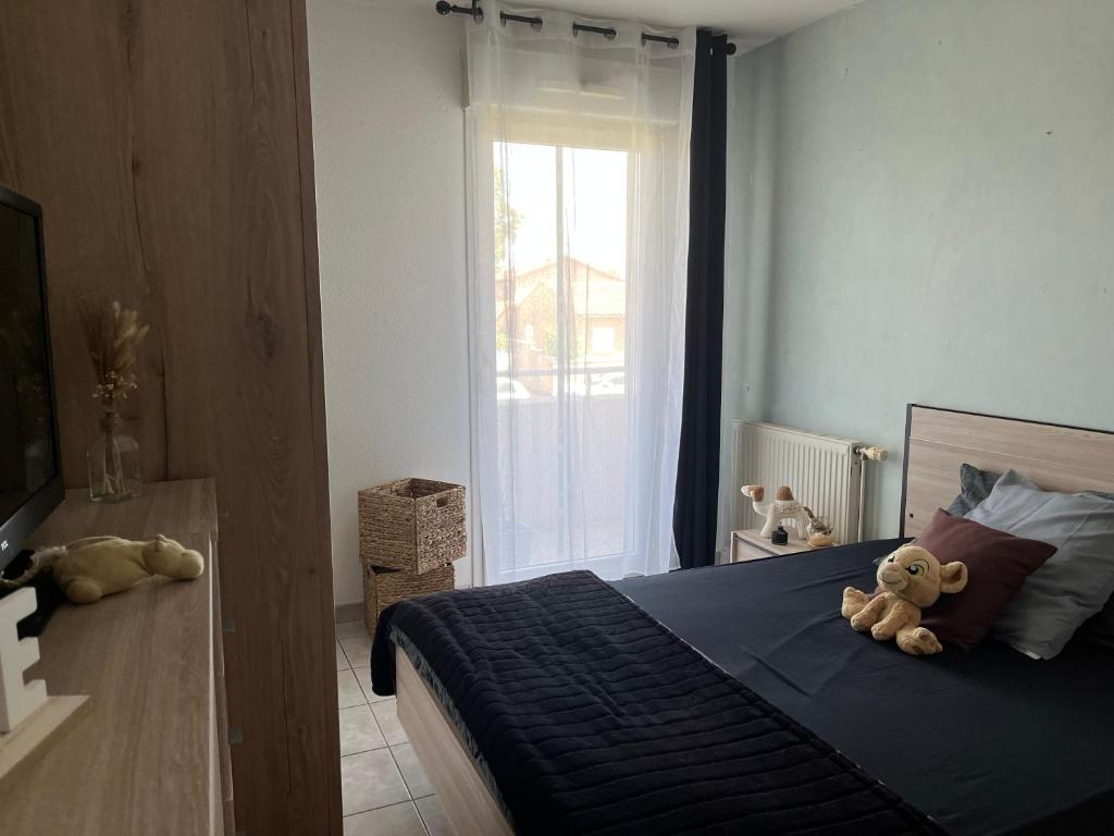 une chambre avec un lit avec deux ours en peluche dessus dans l'établissement chambre équipée vue sur jardin, à La Celle-sous-Gouzon