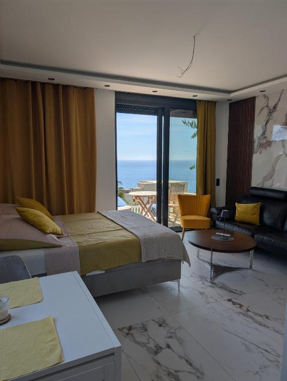 a bedroom with two beds and a view of the ocean at Apartmani Sunce Anja in Dobra Voda