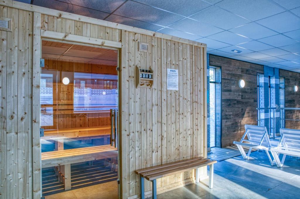 a wooden wall with a bench and chairs in a room at Newlands Holidays in Bridport