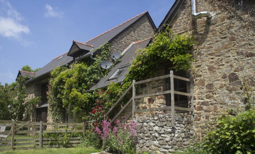 a stone house with flowers on the side of it at Gites Ferme de la Baie in Roz-sur-Couesnon