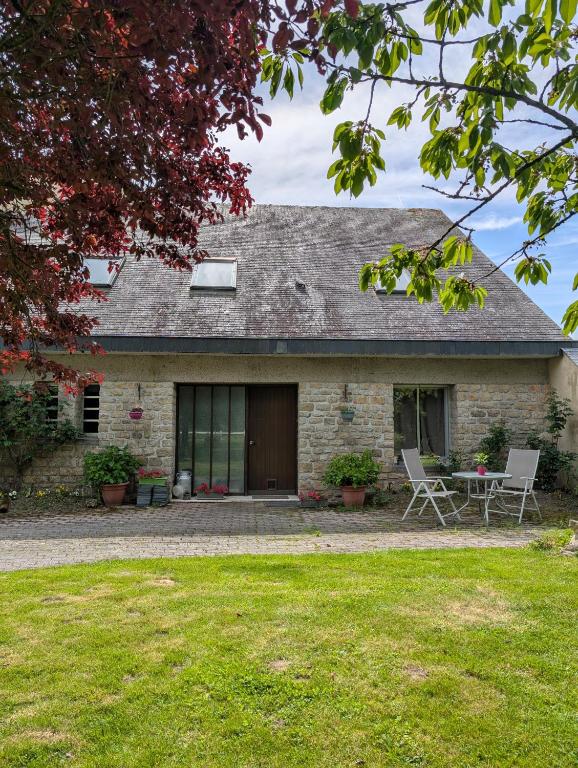 Cette maison en pierre dispose d'une terrasse et d'une table. dans l'établissement A l ombre du Mont Saint Michel, à Huisnes-sur-Mer