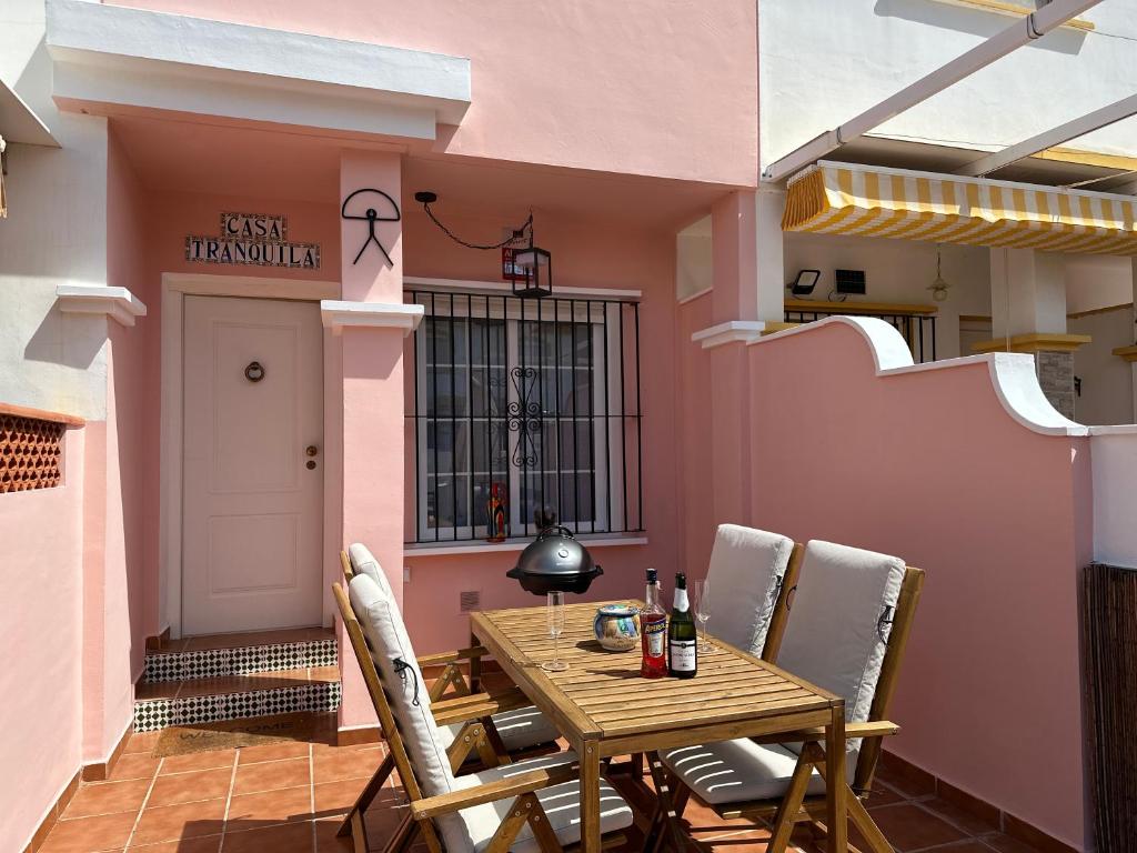 Un patio con una mesa y sillas de madera. en Casa Tranquila, en San Juan de los Terreros