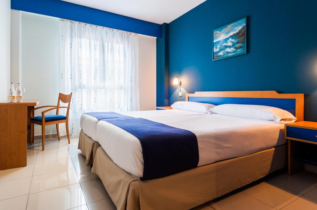 ピントにあるVilla De Pintoの青い壁のベッドルーム1室(大型ベッド1台付)