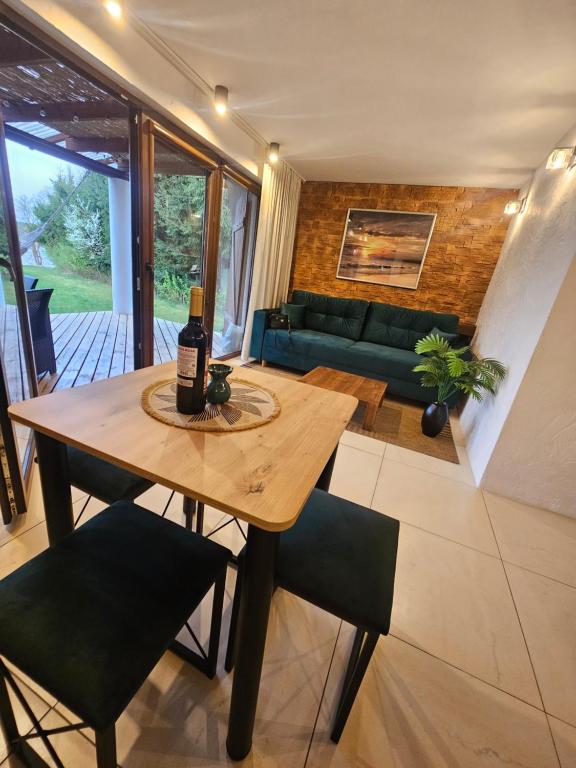 a bottle of wine on a wooden table in a living room at Domek Przy Promenadzie Zdrojowej in Gołdap