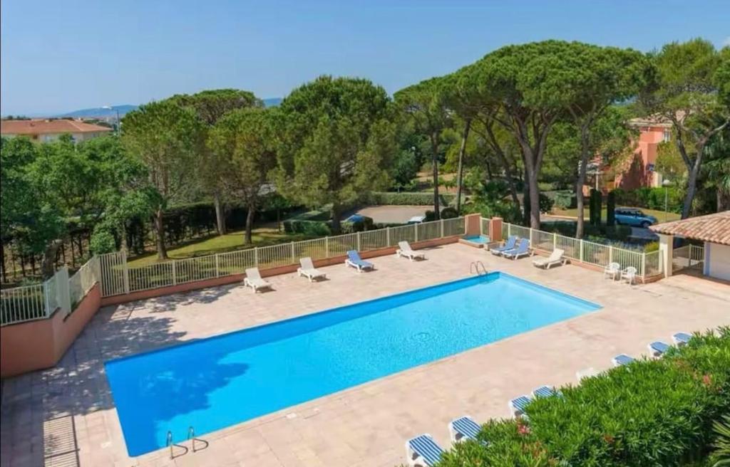 - une piscine dans un complexe avec des chaises et des arbres dans l'établissement Beautiful apartment with pool, golf & beaches, à Saint-Raphaël