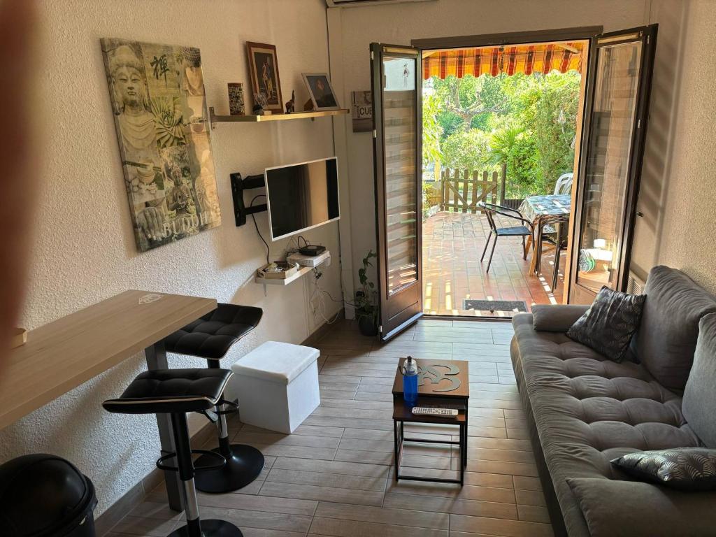 a living room with a couch and a table at Rez-de-jardin proche plage in Cavalaire-sur-Mer