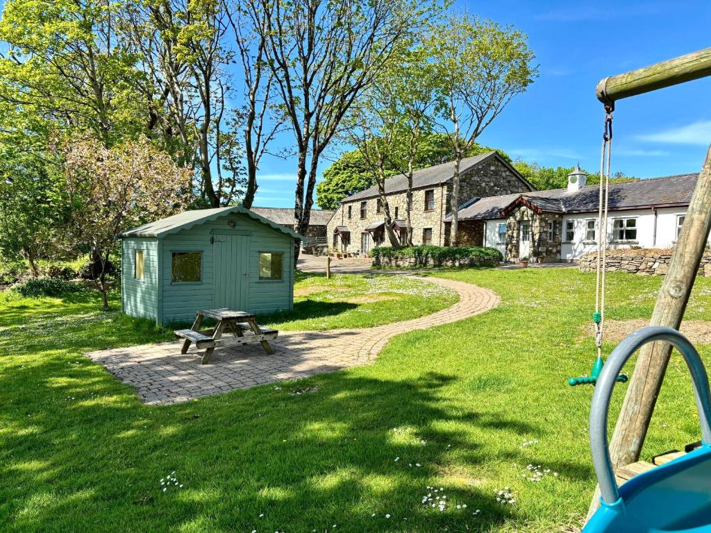 a green shed in a yard with a swing at Kionslieu Farm Cottages in Foxdale