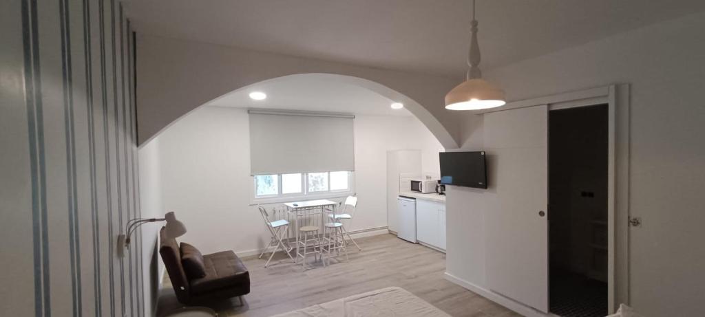 un soggiorno con sedia e una cucina con tavolo di Hostal Terraza Miramar SL a Boiro
