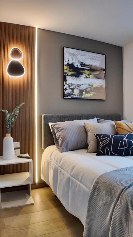 a bedroom with a bed and a painting on the wall at Modern Studio close by La Carolina Metro station in Quito