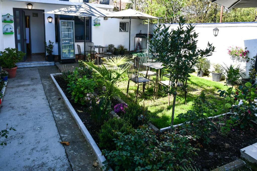 un jardín con mesa y sillas frente a una casa en Hostel 2VB, en Shkodër
