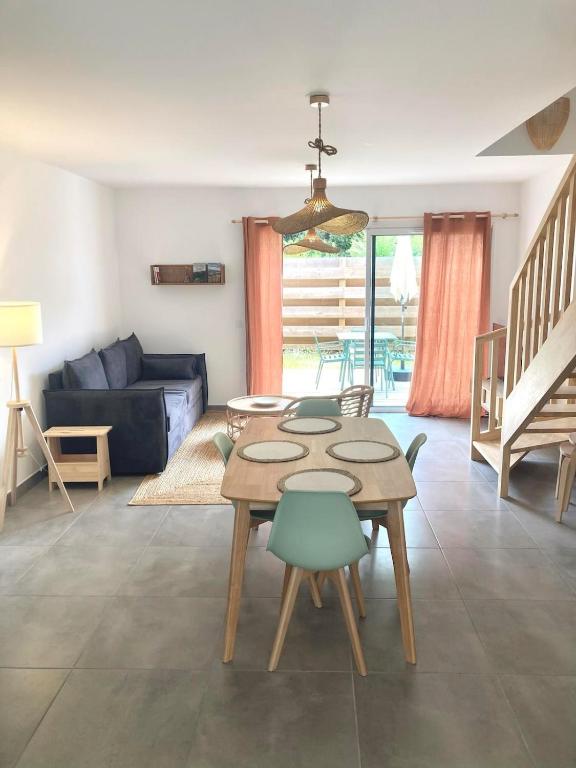 un salon avec une table et un canapé dans l'établissement New house 10 min from the beach, à Lit-et-Mixe