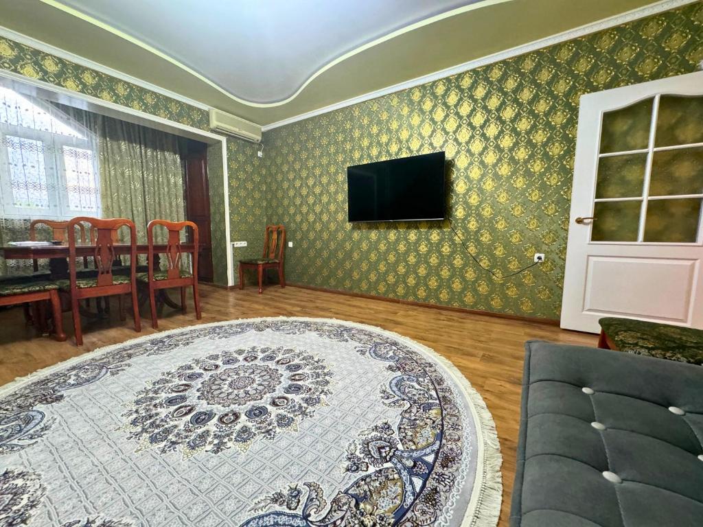 a living room with a rug and a tv on a wall at Large Appartment & Central Place in Tashkent