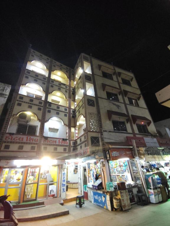 德瓦尔卡hotel shiv的一座建筑,在晚上前有商店