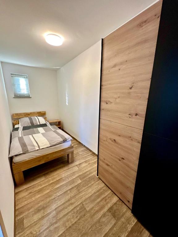 a bedroom with a bed and a wooden sliding door at Ferienwohnung Gerdi in Hoyerswerda