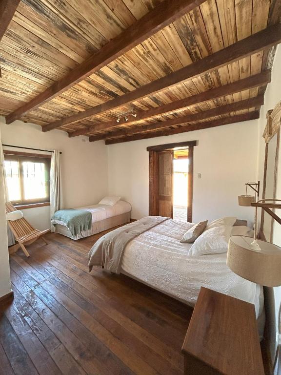 a bedroom with two beds and a wooden ceiling at Casa Antigua Bed and Breakfast Chile in Casablanca
