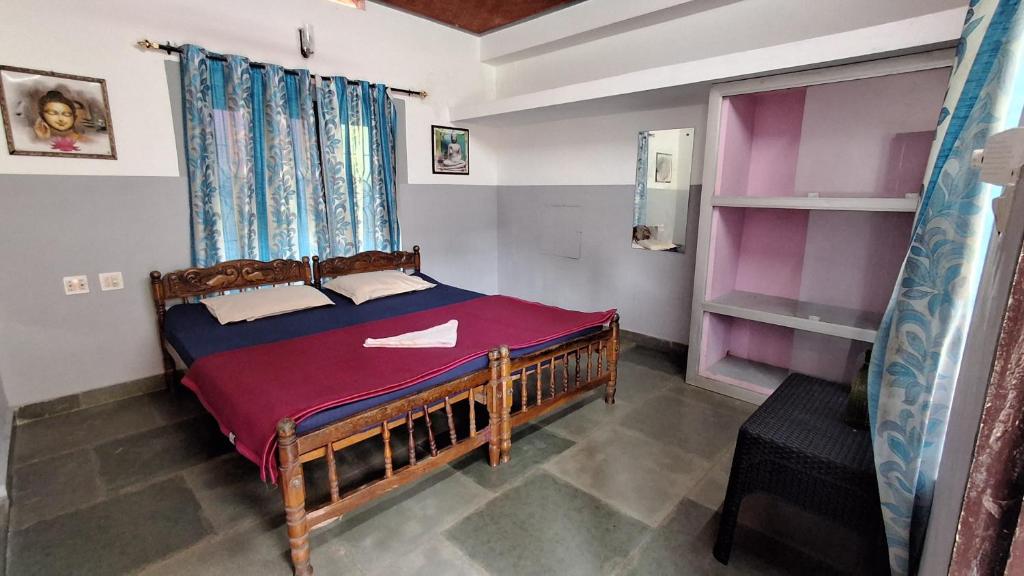 a bedroom with a bed with a purple blanket at Swargam Pool Resort in Varkala