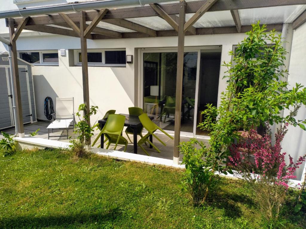a patio with green chairs and a table at "KALEE" Appartement T3 Terrasse avec petit jardin in Lanester