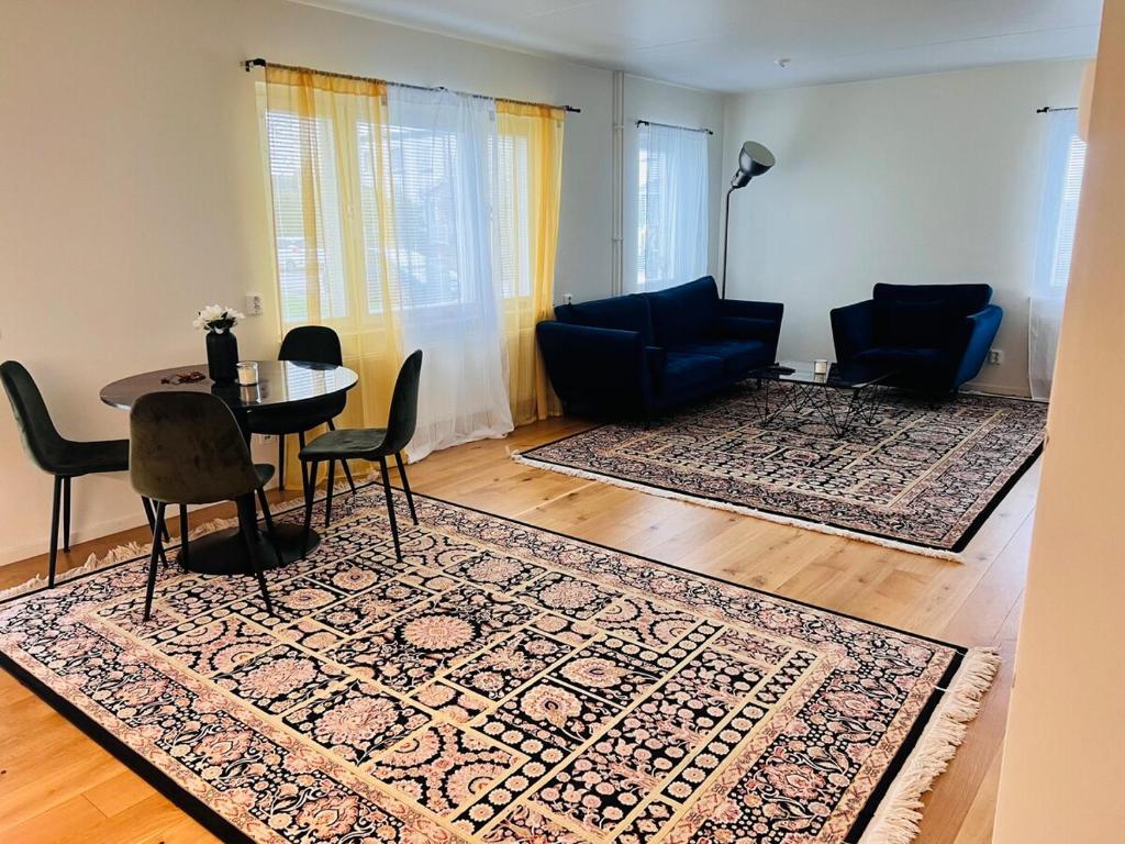 a living room with a table and chairs and a rug at Awesome home in Bro