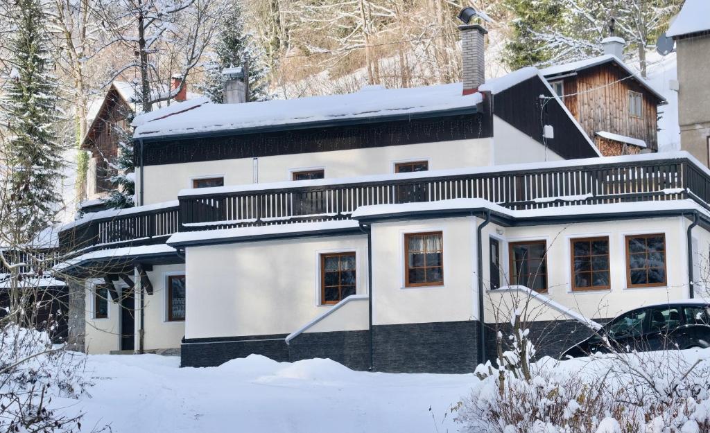a white house with snow on the ground at Penzion Mája - przytulny pensjonat blisko szlaków i stoków w Karkonoszach in Paseky nad Jizerou