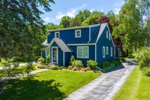 een blauw huis met een oprit ervoor bij Hudson Ave Loft in Sturgeon Bay