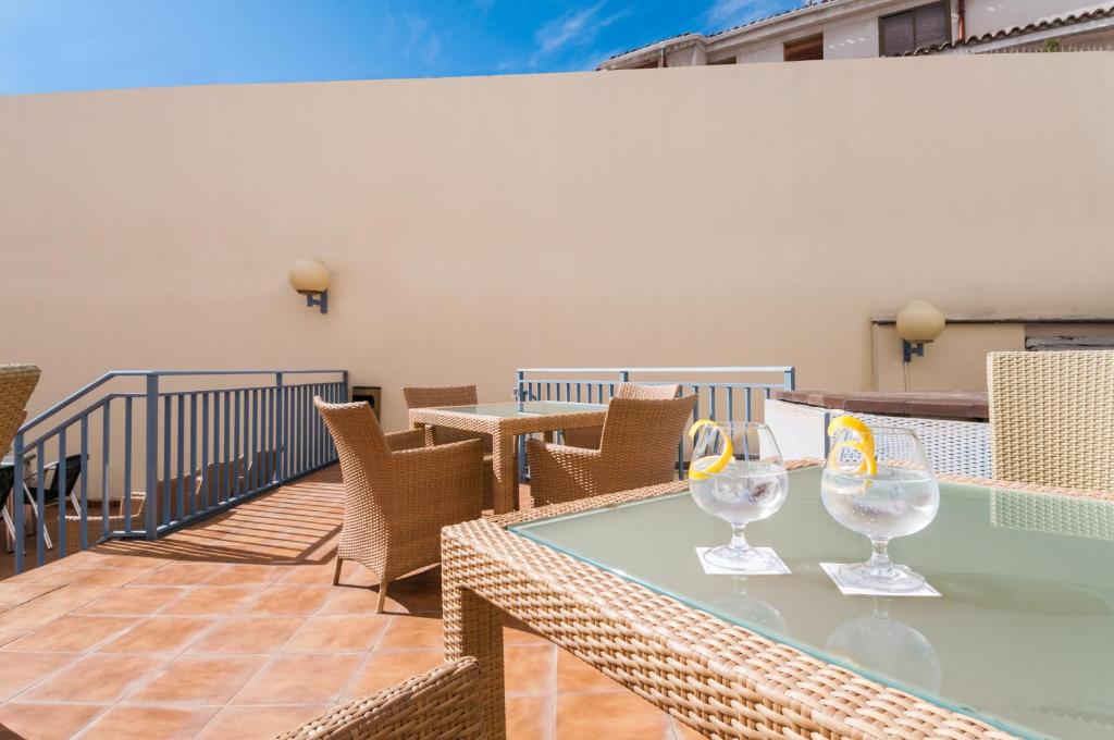 una mesa con copas de vino en el balcón en Hotel Villa De Pinto, en Pinto