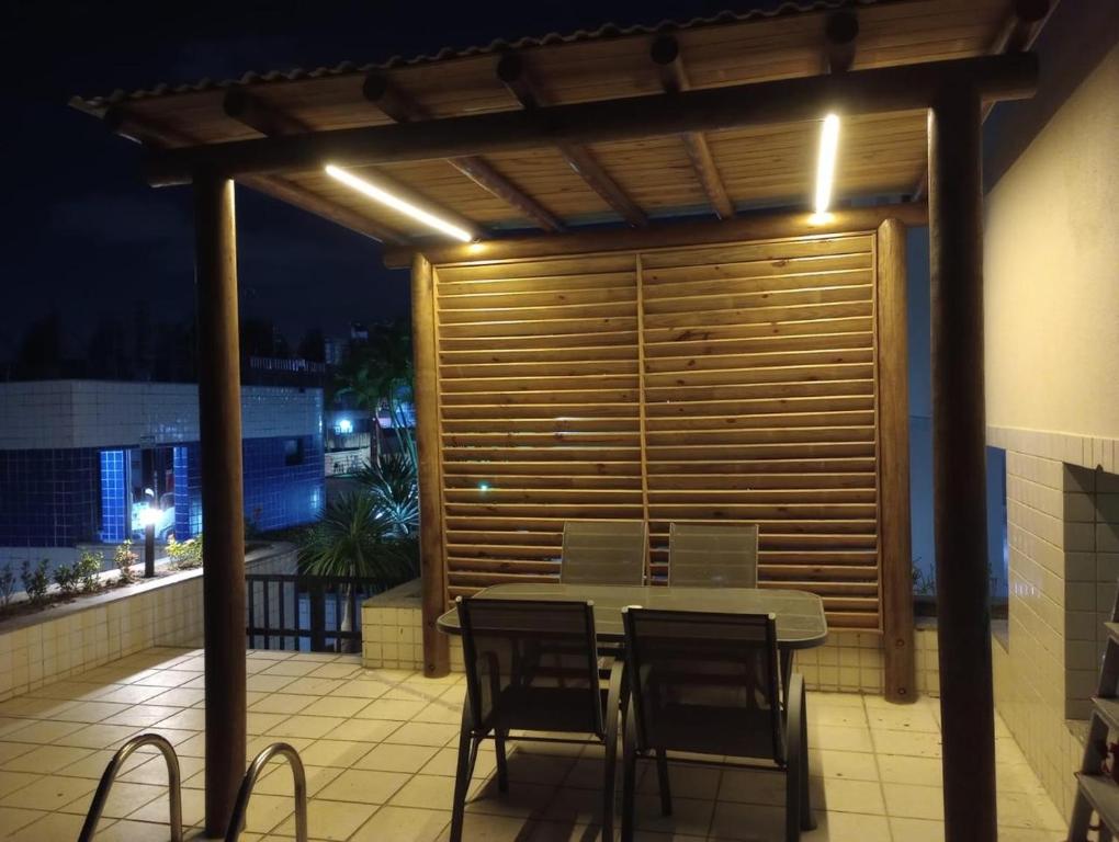 a table and chairs on a patio at night at Apartamento próximo a praia in Maceió