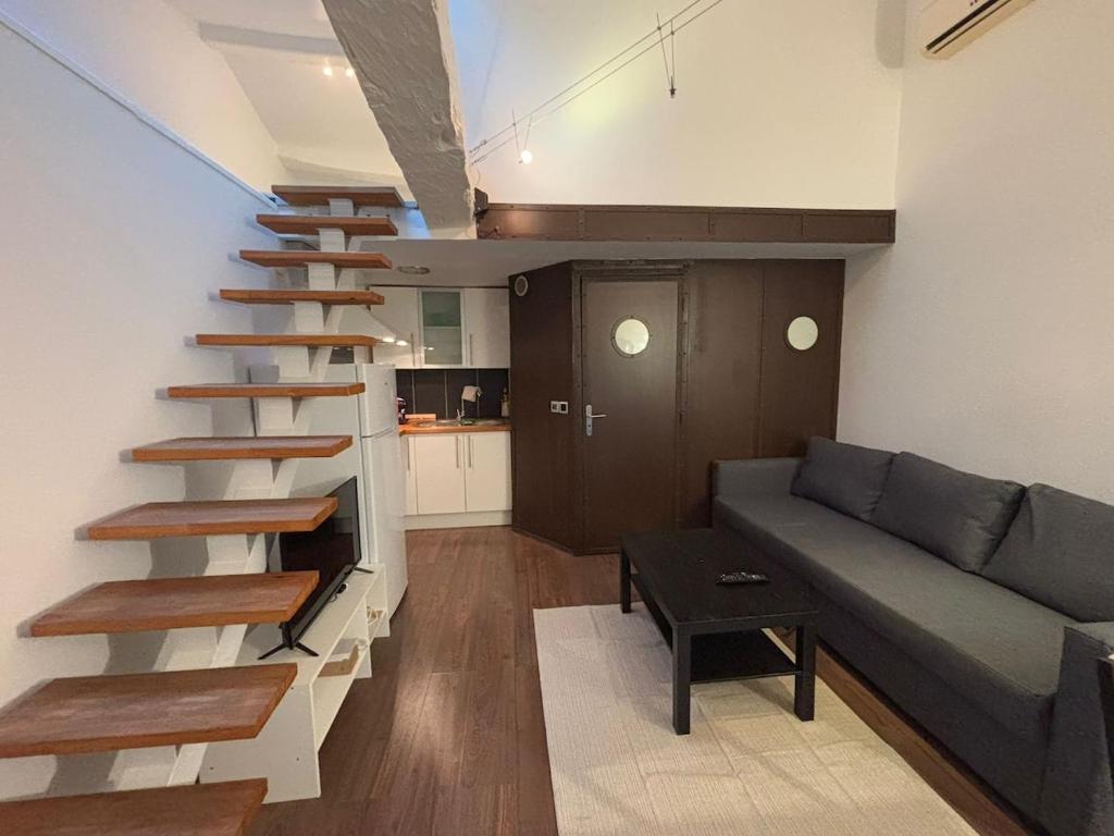 a living room with a couch and a staircase at Charmant duplex in Clermont-Ferrand