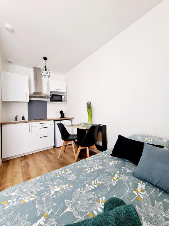 une chambre avec un lit et une table et une cuisine dans l'établissement Studio 2 Cosy en centre-ville - Puy duFou, aux Herbiers