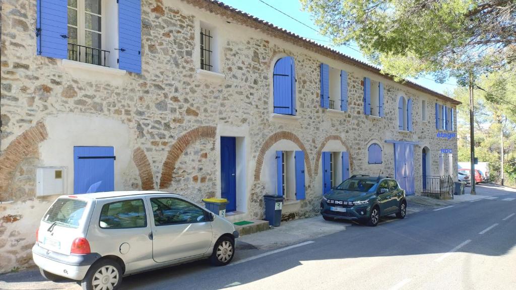 deux voitures garées devant un bâtiment avec portes bleues dans l'établissement Joli T2 RDC ancienne bergerie, à La Seyne-sur-Mer