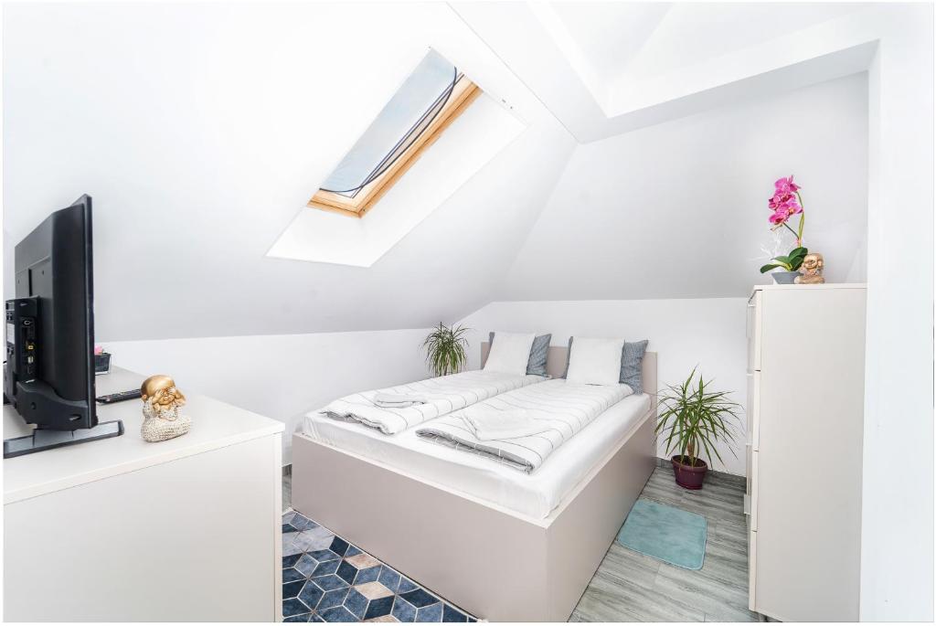 a white room with a bed and a tv at Bloc nou cu parcare privata - Hella apartament in Giroc
