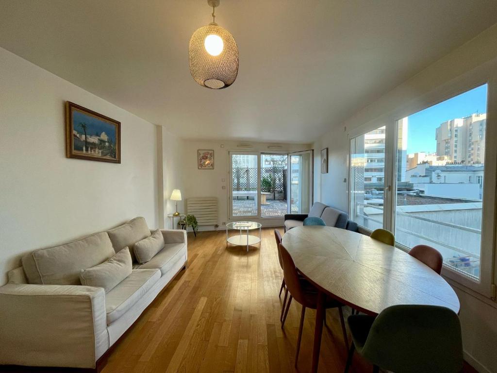 un salon avec un canapé et une table dans l'établissement Appartement Montparnasse Castagnary Paris, à Paris