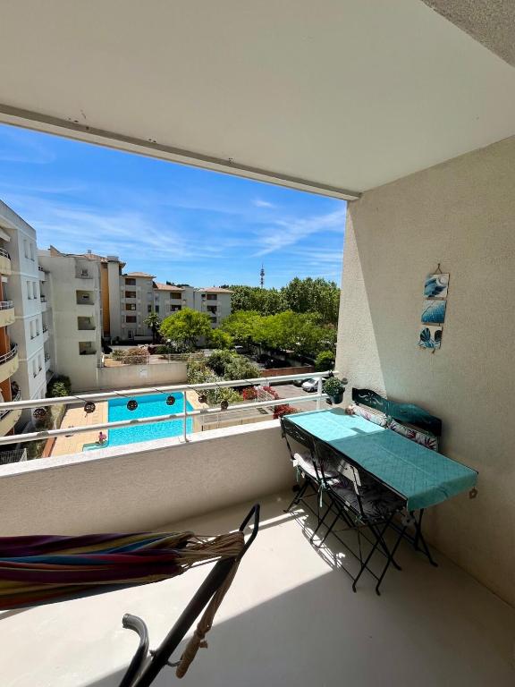d'un balcon avec une table et des chaises, ainsi que d'une piscine. dans l'établissement Chez Mya, à Montpellier
