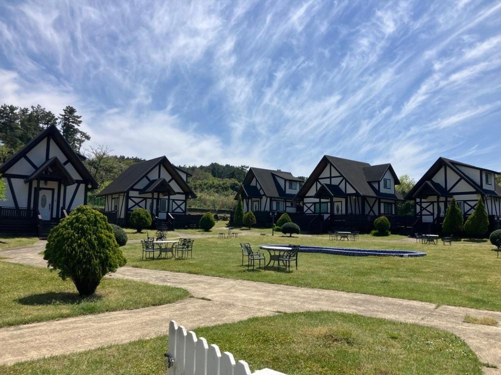 a row of houses with tables and a fence at Jeju Mungmung Place Dog Pension in Jeju