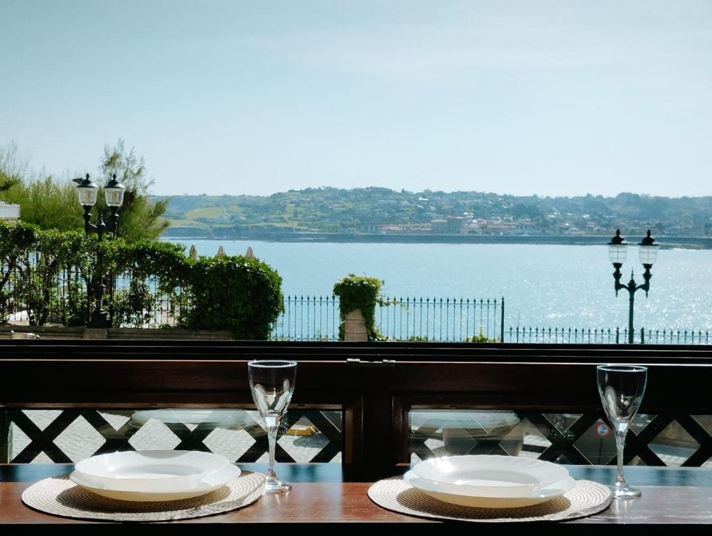 een tafel met twee borden en glazen erop bij Apartamento Cimadevilla 22 in Gijón