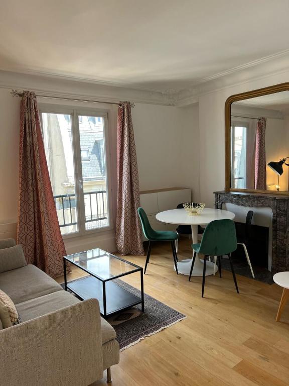 un salon avec un canapé et une table dans l'établissement Beautiful Flat Paris Monceau Champs Élysée, à Paris