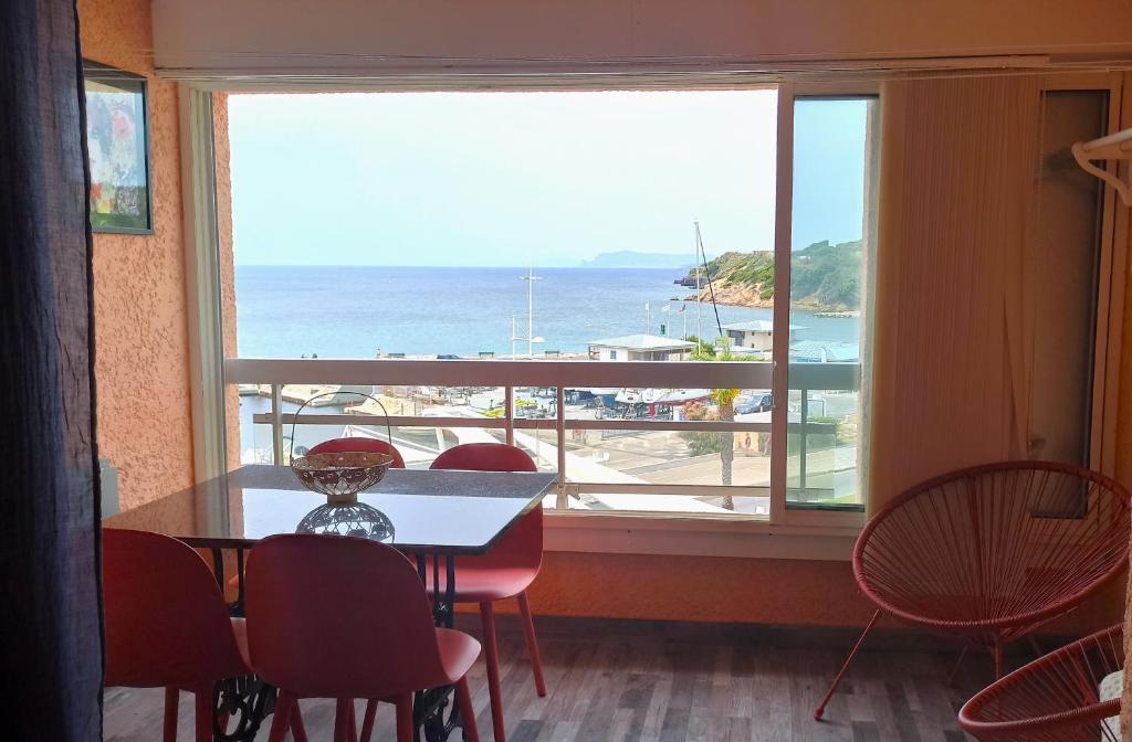 une salle à manger avec une table et des chaises et une grande fenêtre dans l'établissement A PIEDS NUS JUSQU'A LA MER, à Six-Fours-les-Plages