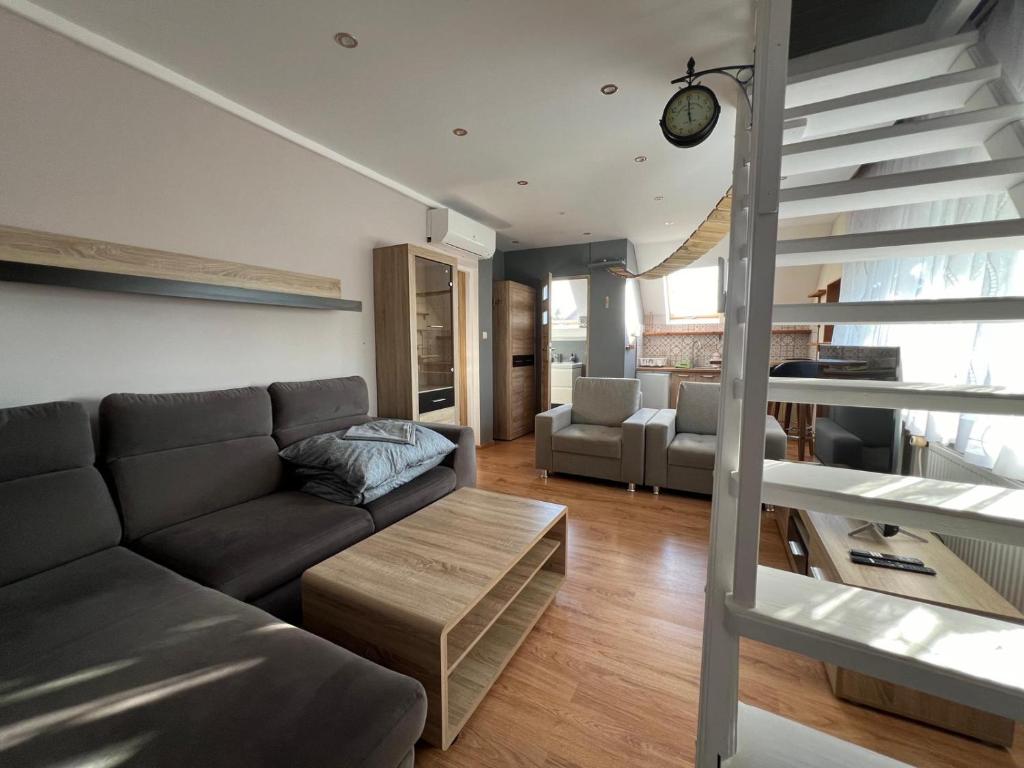 a living room with a couch and a staircase at Olivia in Sianozety
