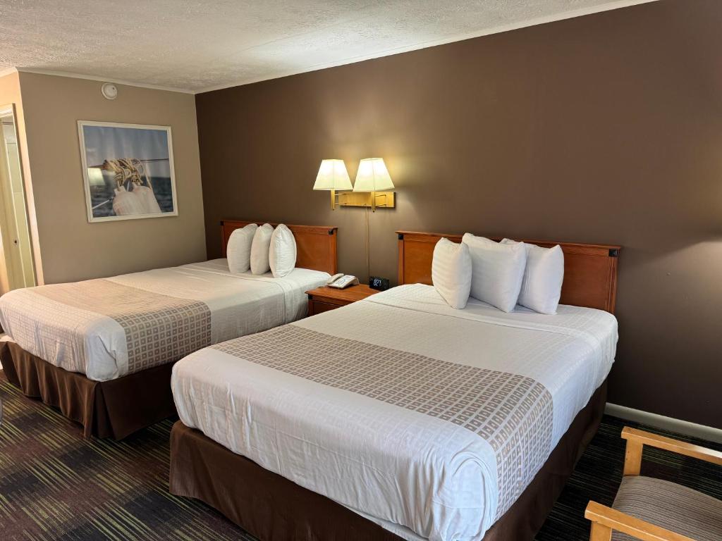 a hotel room with two beds with white sheets at South Shore Inn in Sandusky