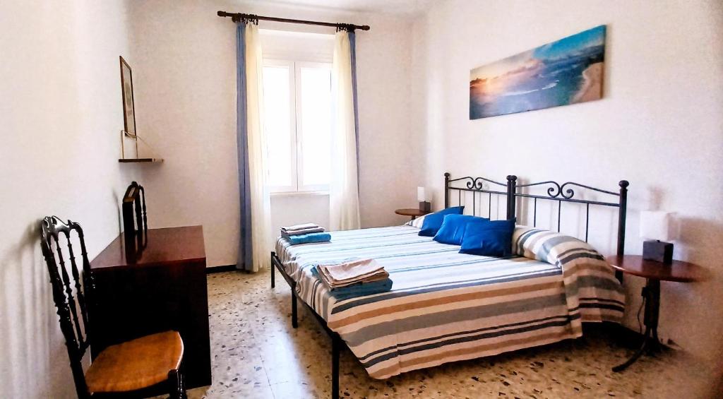 a bedroom with a bed with blue pillows and a window at CASA PEONIA Lovely Flat in Moneglia