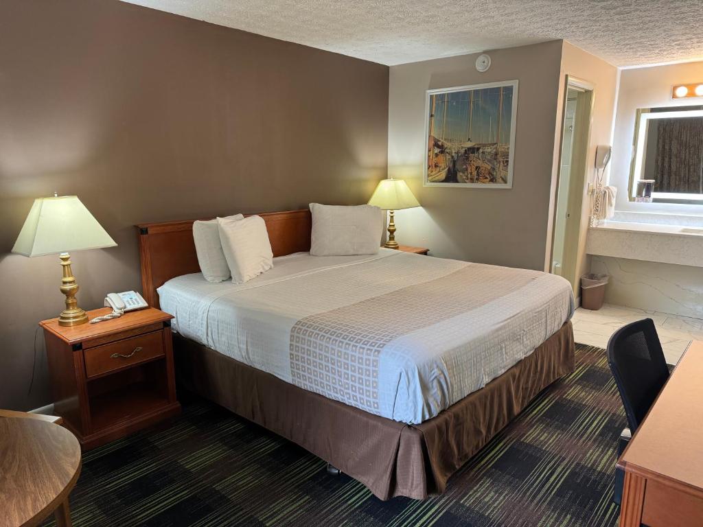 a hotel room with a large bed and a table at South Shore Inn in Sandusky