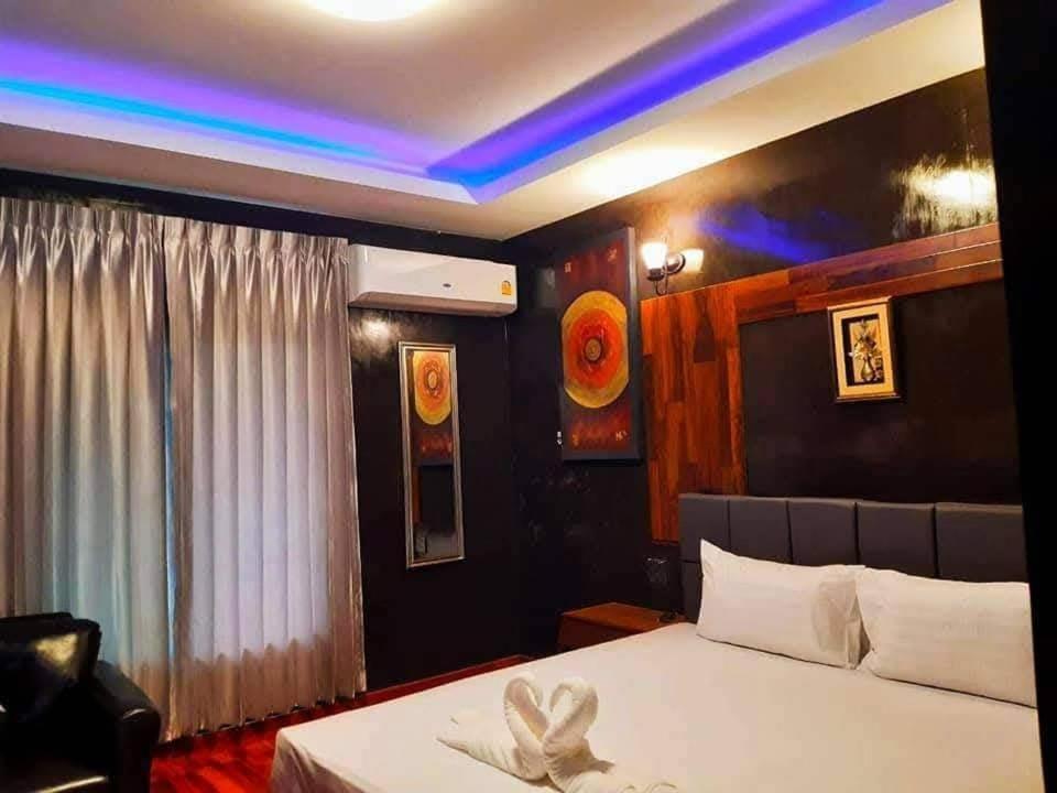 a bedroom with a bed with a white bedspread at นาธาริเวอร์ไซด์ in Ban Lamphu La (3)