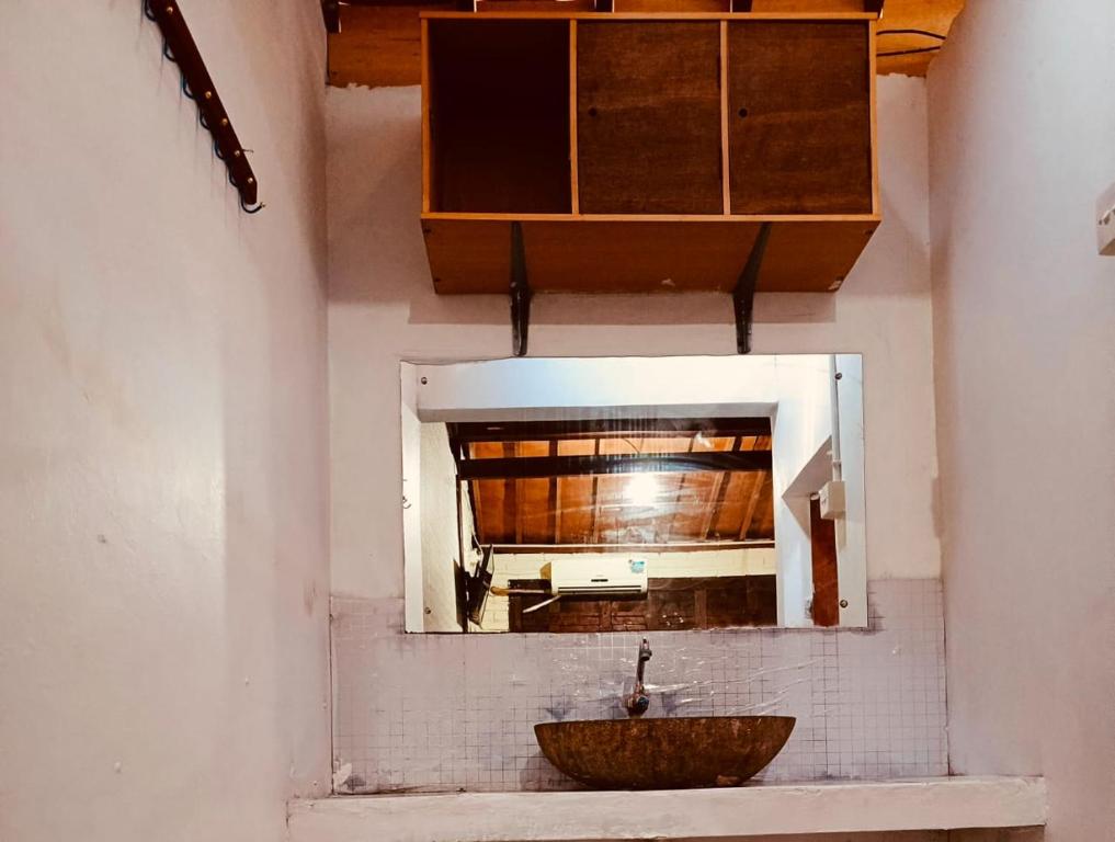 un baño con lavabo y espejo en Jimbaran homestay, en Mantaak