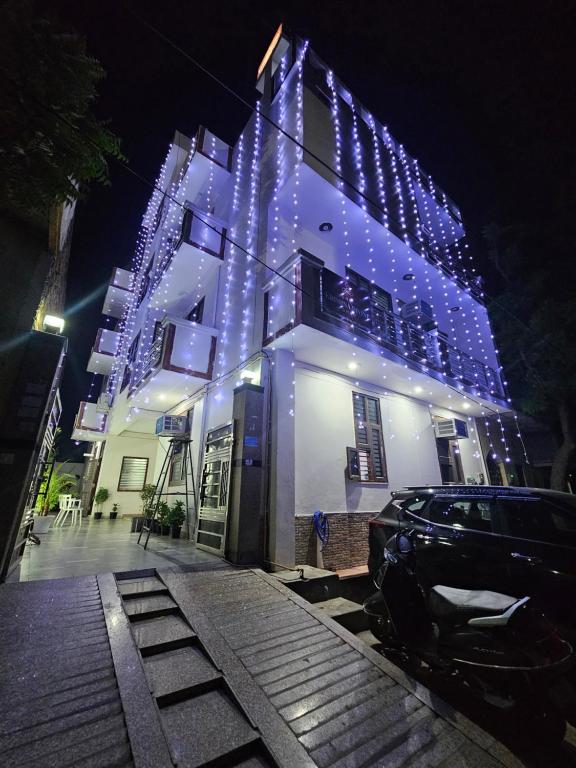 a building with lights on it with a car parked in front at Shri Krishna Divine Dham in Mathura